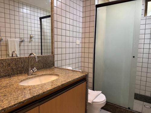 a bathroom with a sink and a toilet at Flat ou Bangalo Luxo Beach Class Beira Mar Muro Alto in Porto De Galinhas