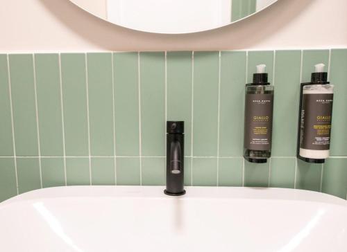 a bathroom with three bottles ofodorizers on a sink at Montebello Comfort in Ancona