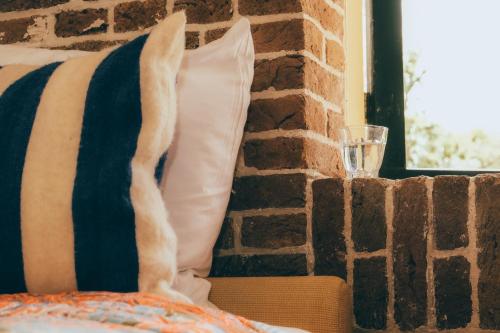 a pillow sitting on a bed next to a brick wall at Fort Vuren in Vuren