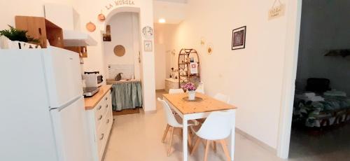 a kitchen with a small table and a white refrigerator at LA MURGIA casa vacanze B&B in Grumo Appula