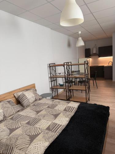 a bedroom with a bed and a table and chairs at Apartamenti Upesgrīvā in Upesgrīva