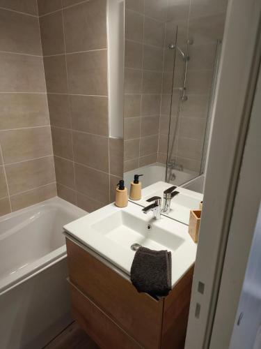 a bathroom with a sink and a bath tub at Les Chambres de Nelly in Cravant-les-Coteaux