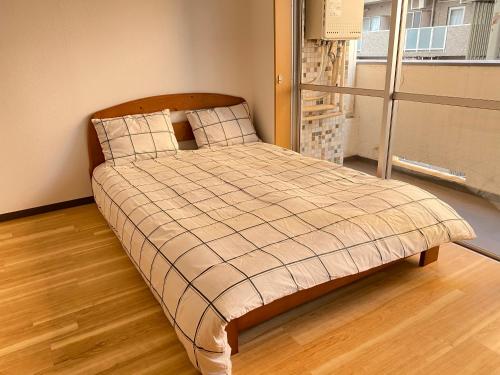 a bed with a plaid blanket in a room at The Abe Ikebukuro in Tokyo