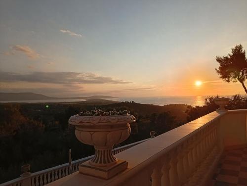 a vase on a balcony with the sunset in the background at Lunamora 2 in Rodi Garganico