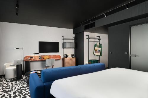 a bedroom with a blue couch and a bed at TRIBE Budapest Airport in Budapest