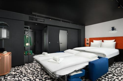 a room with three beds in a room at TRIBE Budapest Airport in Budapest
