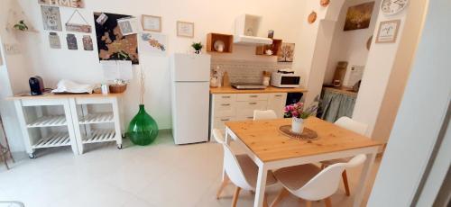 a kitchen with a table and a white refrigerator at LA MURGIA casa vacanze B&B in Grumo Appula