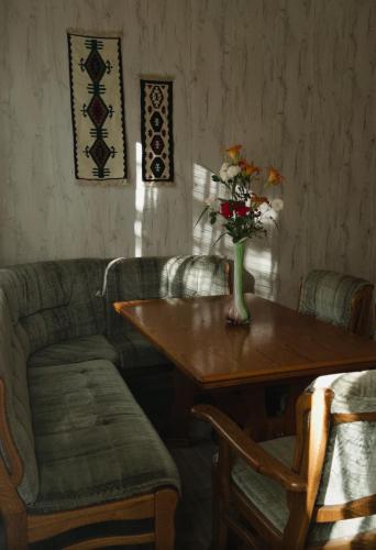 a table with a vase of flowers on top of it at Guest house-Lile in Mestia