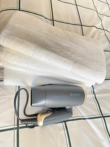 a hair dryer sitting on top of a bed at The Abe Ikebukuro in Tokyo