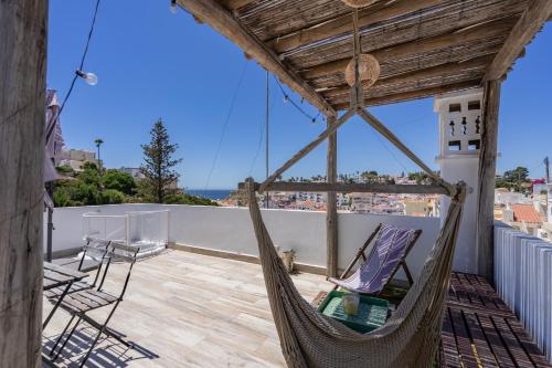 a hammock on a balcony with a view of the ocean at Sea view studio Carvoeiro in Carvoeiro