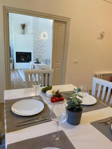 a table with two plates and wine glasses on it at Sohora Villa in Éxo Goniá