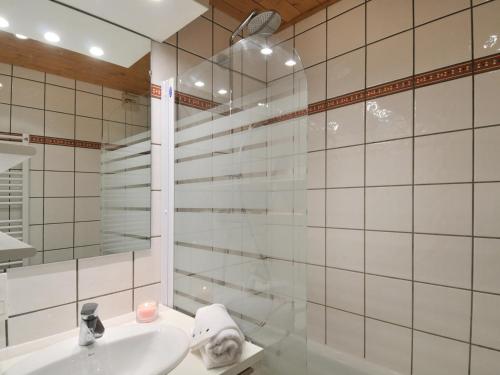 une salle de bain blanche avec un lavabo et une douche dans l'établissement Studio rénové au pied des pistes, balcon, pour 4 personnes - FR-1-181-2097, à La Plagne Tarentaise