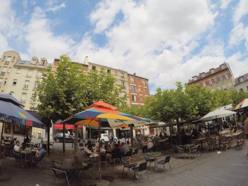 a group of people sitting at tables under umbrellas at Lumineux & cosy proche Paris & La Défense, commerces & transports, PARKING in Suresnes