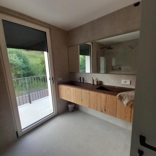 a bathroom with a sink and a large mirror at Riflessi sul lago in Baselga di Pinè