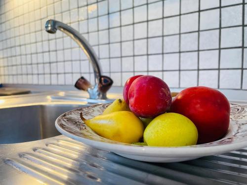 a bowl of apples and pears on a counter at Mendrisio Deluxe Apartament in Mendrisio