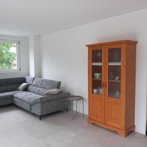 a living room with a couch and a cabinet at Riflessi sul lago in Baselga di Pinè