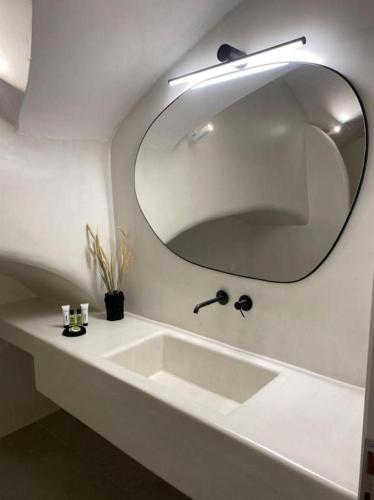 a bathroom with a white sink and a mirror at Sohora Villa in Éxo Goniá