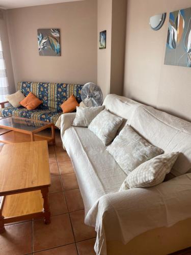 a living room with a couch and a couch and a table at perla blanca in Peñíscola