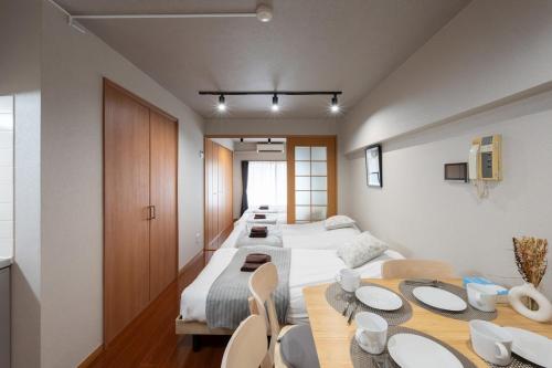 a room with two beds and a table and chairs at Near Shibuya Station 4Beds 5Max A175 in Tokyo