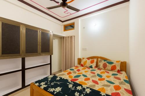 a bedroom with a bed and a ceiling fan at Sudama Dham Homestay in Ayodhya