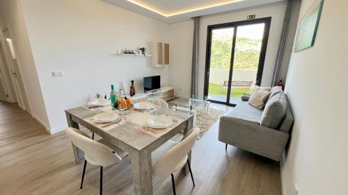 a dining room with a table and chairs and a couch at The Barreto's Clive in Ponta do Sol