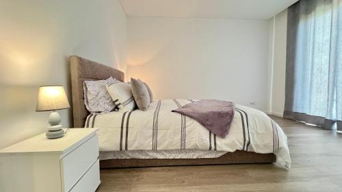 a bedroom with a bed and a dresser with a lamp at The Barreto's Clive in Ponta do Sol