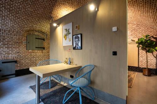 a table and chairs in a room with a brick wall at Fort Vuren in Vuren