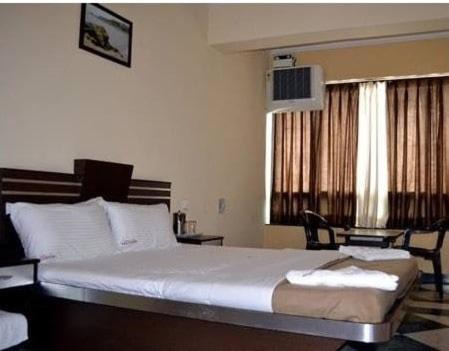 a bedroom with a large white bed in a room at Hotel Navadeep in Cuncolim