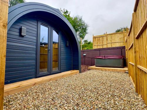 a blue shed sitting next to a building at 60 Mile Inn - Luxury Pods with Hot Tubs in Bridge of Orchy