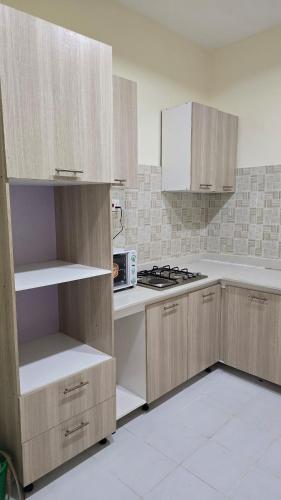 a kitchen with wooden cabinets and a stove top oven at Haven Height Executive Luxury Apartment in Lekki