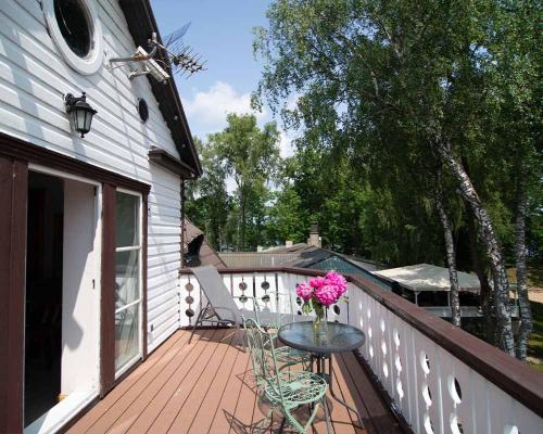 a balcony with a table with a vase of flowers on it at Slėnis Trakuose in Trakai