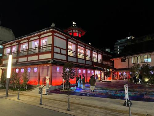a building with people standing outside of it at night at パインツリー in Matsuyama