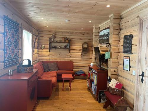 a living room with a couch in a room with wooden walls at Blazerbu Four-Bedroom Chalet in Hol