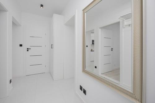 a bathroom with white cabinets and a mirror at Wyjątkowy Apartament dla 4 osób by Noclegi Renters in Pruszków