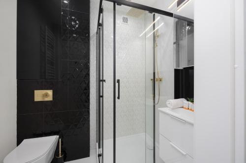a bathroom with a glass shower stall and a toilet at Wyjątkowy Apartament dla 4 osób by Noclegi Renters in Pruszków