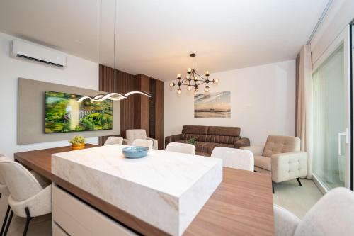 a kitchen and living room with a table and chairs at Bumblebee apartments & rooms with pool in Novalja
