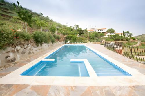a large swimming pool with blue water at Casa Rural Albaida in Laroya