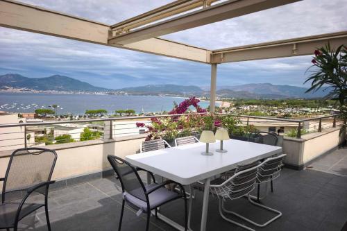 a table and chairs on a balcony with a view of the water at Apartment with terrace close to the beach in Grosseto-Prugna