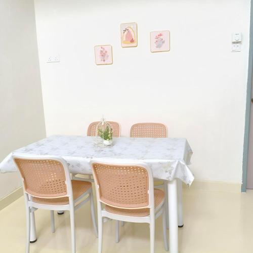 a dining room table with four chairs and a white table at Simee Terrance Cozy Stay in Gua Sai