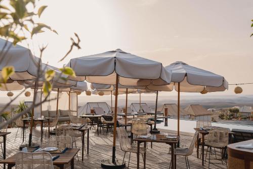 a group of tables and chairs with umbrellas on a deck at Mia Agafay Resort in El Karia