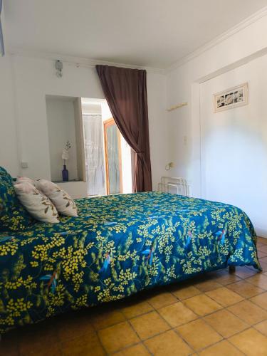 - une chambre avec un lit doté d'une couverture bleue et d'oreillers dans l'établissement Auravignon, à Sorgues