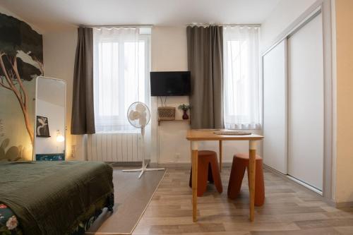 une chambre avec un lit, un bureau et une table dans l'établissement Le Cocon de Cordeliers, à Lyon