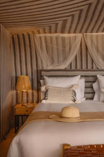 a bedroom with a bed with a hat on it at Mia Agafay Resort in El Karia