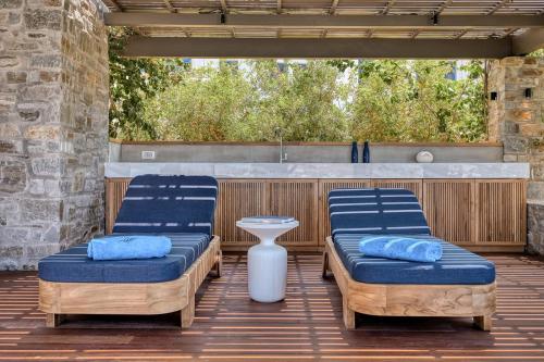 two beds and a table on a patio at Avant Mar Paros in Naousa