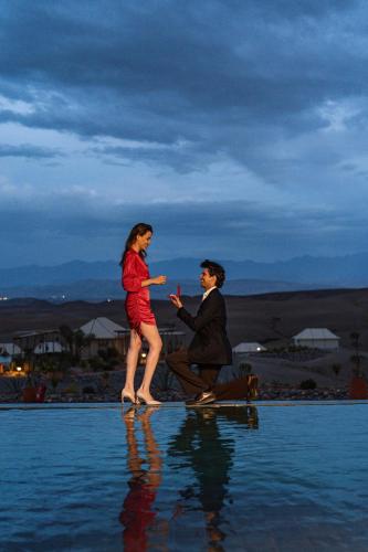 a man and a woman are standing in the water at Mia Agafay Resort in El Karia