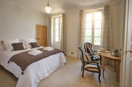 a bedroom with a bed and a table and chairs at Ferme Saint-Georges en Provence in Le Val