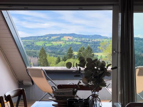 a room with a table and a window with a view at Terrazzo Panoramico - Vicino ad Asiago in Roana