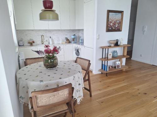 a kitchen with a table with a vase of flowers on it at Ostoya in Rumia