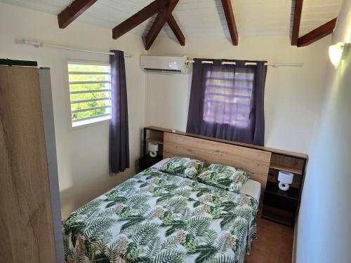 ein Schlafzimmer mit einem Bett und einem Fenster in der Unterkunft ÉLÉGANT APPARTEMENT À LA CAMPAGNE in Sainte-Anne