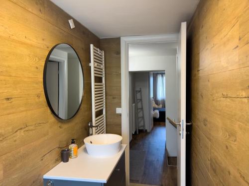 a bathroom with a sink and a mirror on a wall at Terrazzo Panoramico - Vicino ad Asiago in Roana